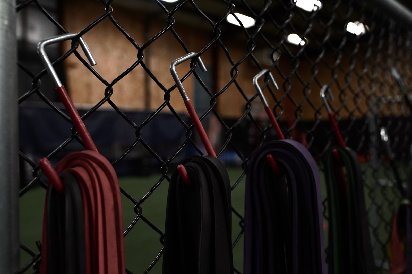 Resistance bands hang on the fence beside the turf
