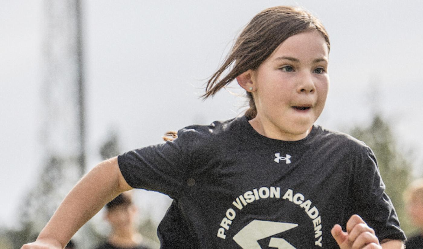 A young athlete runs through an agility drill in a Pro Vision shirt